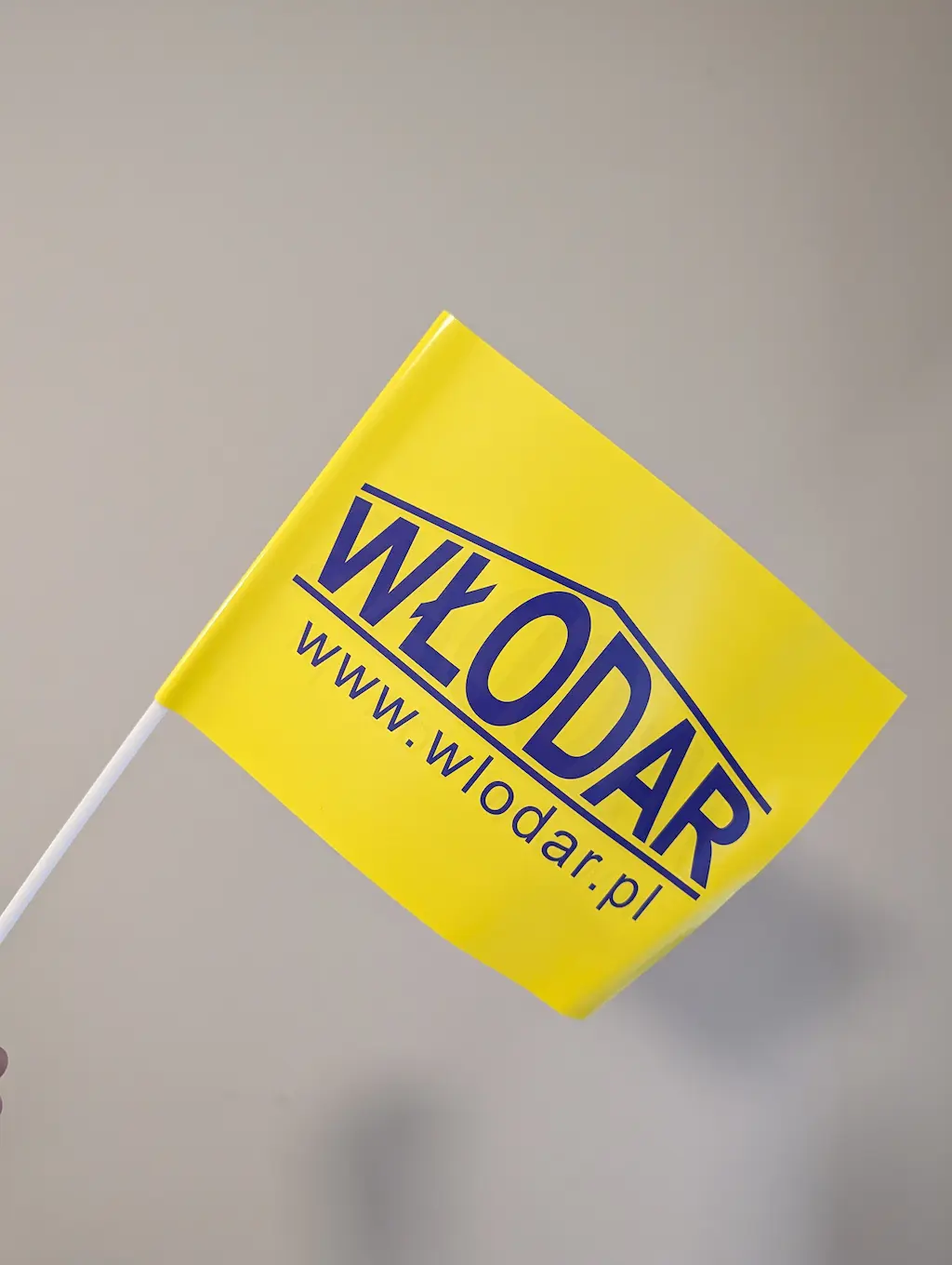 Żółte chorągiewki papierowe z nadrukiem logo Włodar na patyczku