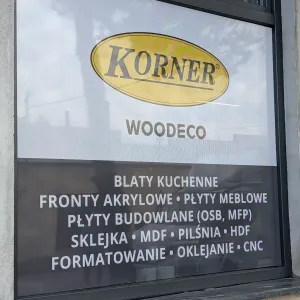 Oklejanie witryny folią OWV One Way Vision z logo KORNER WOODECO i ofertą płyt meblowych