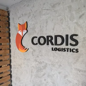 Logo przestrzenne ze styroduru CORDIS LOGISTICS montowane na ścianie z betonu architektonicznego