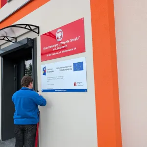Montaż unijnej tablicy informacyjnej KPO oraz tablicy urzędowej z godłem dla Klubu Dziecięcego Wesołe Smyki w Ładzicach